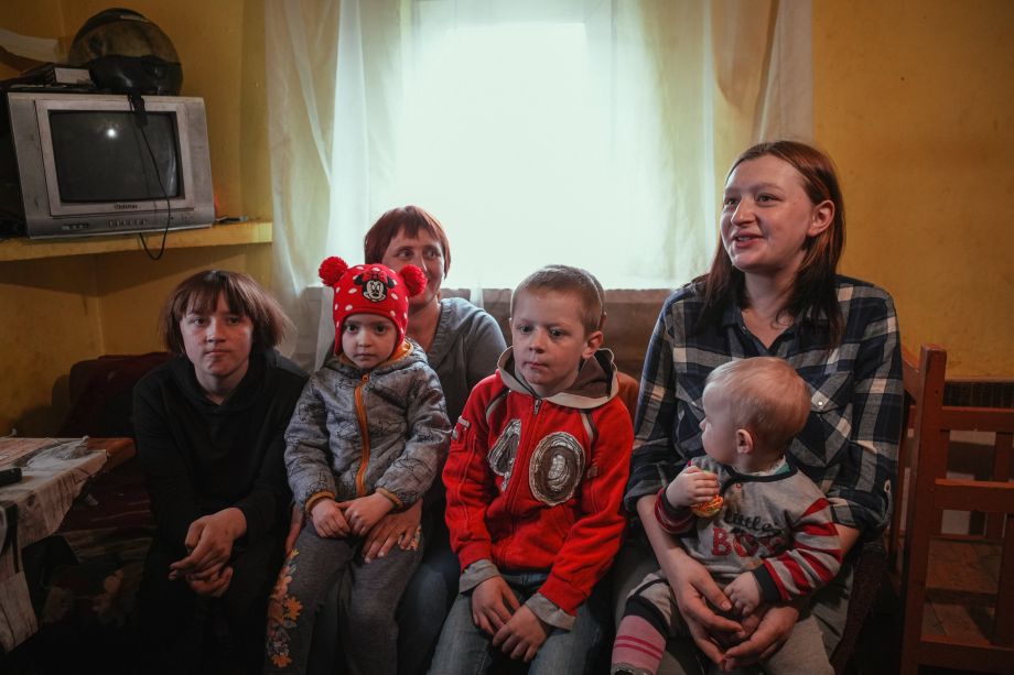 Valeria and he children are sitting on a couch talking to Mission to Ukraine.